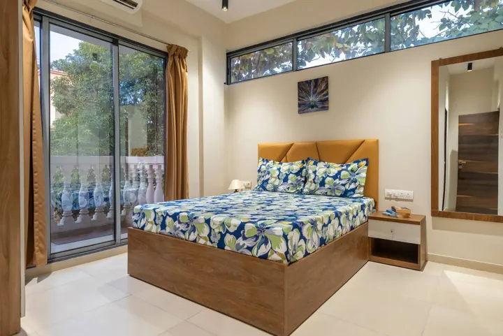 Bedroom with wooden bed and balcony